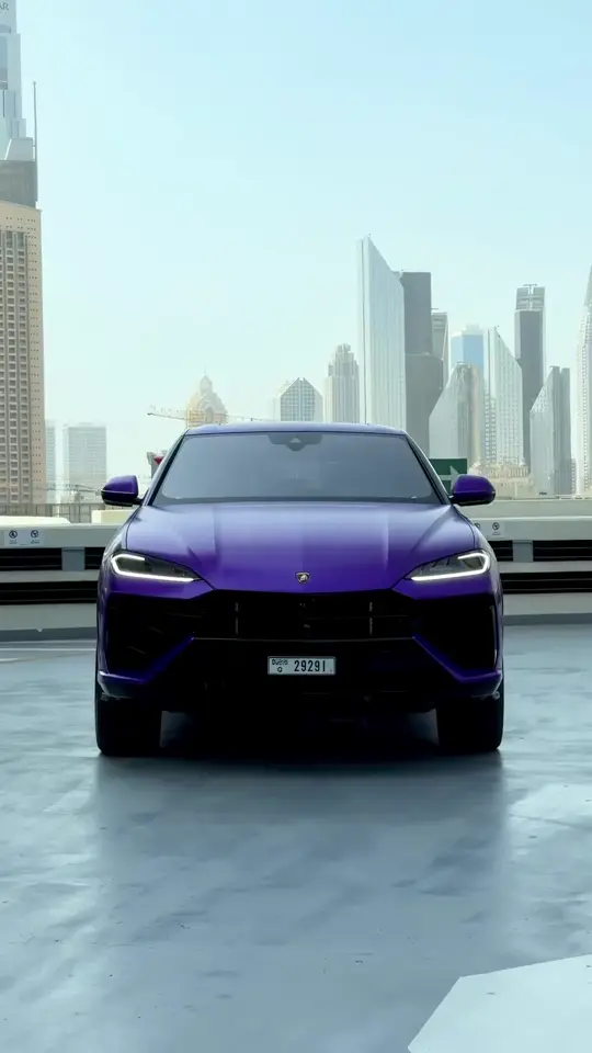 Purple Lamborghini Urus in front of the Dubai skyline